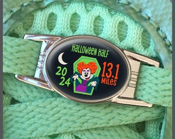 May include: A silver shoe charm with a black and green design featuring a cartoon witch and the text "Halloween Half 13.1 Miles 2024".