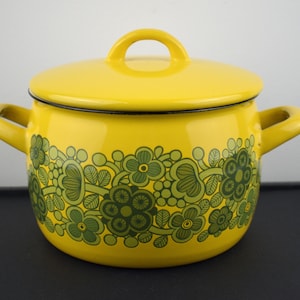 May include: Yellow enamel pot with a green floral design. The pot has a lid and two handles.
