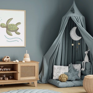 A framed illustration of a sea turtle in a wooden frame hanging on the wall in a blue boy’s bedroom