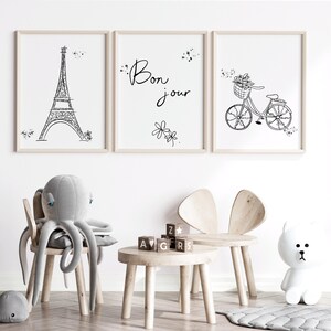 Three Paris inspired line art drawings in frames in playroom with toys