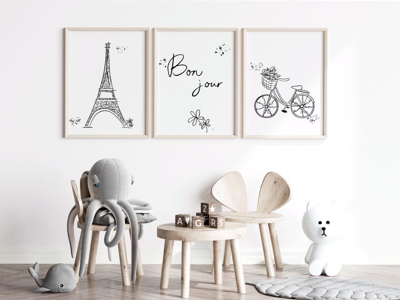 Three Paris inspired line art drawings in frames in playroom with toys