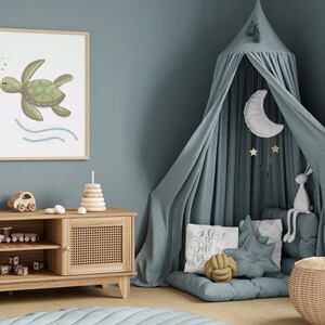 Illustration of sea turtle art in a wood frame hung on a blue wall in a child’s room with toys