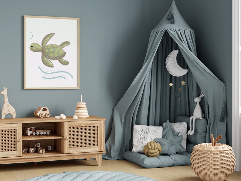 Illustration of sea turtle art in a wood frame hung on a blue wall in a child’s room with toys