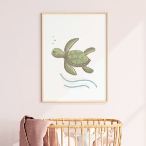 Illustration of sea turtle nursery art in a wood frame hung on a pink wall in a nursery