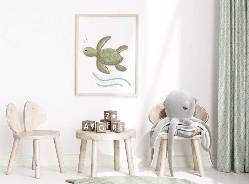 Illustration of sea turtle nursery art in a wood frame hung on a white wall in a children’s playroom with toys