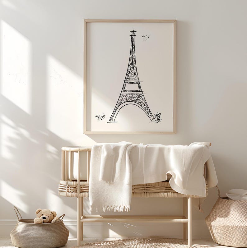 Black and white Eiffel Tower line drawing in frame in neutral nursery above a crib