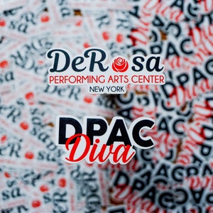 May include: Close-up of two stickers. The first sticker is white with black text that reads "DeRosa Performing Arts Center New York". The second sticker is white with black text that reads "DPAC Diva". Both stickers have a red rose graphic.