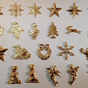 May include: A collection of 20 gold-colored metal Christmas ornaments featuring various designs, including snowflakes, stars, angels, a snowman, a wreath, a reindeer, and a Christmas tree.