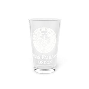 Puede incluir: Un vaso de pinta de vidrio transparente con un diseño grabado en blanco del sello de la República de Texas, con el texto "The Republic of Texas 1836" y "Texas Embassy London".