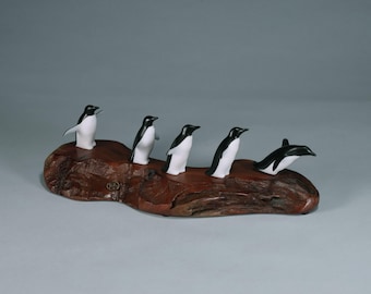 5 penguin flock by John Perry 11 in long on polished burl slab. Signed.