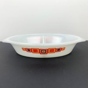 May include: White divided oval baking dish with a geometric pattern of orange and brown squares.