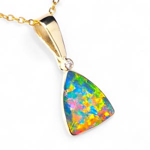 May include: A gold pendant necklace with a triangular opal gemstone displaying a spectrum of colours including blue, green, yellow, and pink. The pendant has a small diamond and hangs from a delicate gold chain.