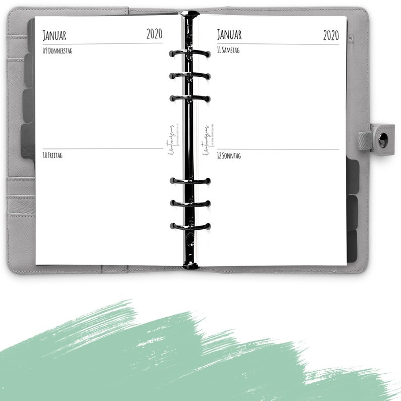 Puede incluir: Una agenda gris con un encuadernador negro y el texto "JANUAR 2020" en la portada. La agenda est&aacute; abierta en la primera p&aacute;gina, que est&aacute; en blanco.