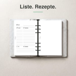Könnte beinhalten: Ein hellgrauer Ringbuchordner, der auf einer Seite mit dem Text Liste. Rezepte. aufgeschlagen ist. Die linke Seite enthält gedruckte Abschnitte für Rezeptdetails wie Zutaten, Zubereitung, Zeit und Bemerkungen, während die rechte Seite leer ist.