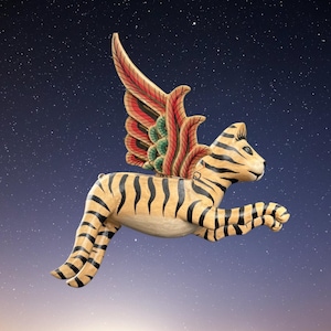 May include: A wooden sculpture of a tiger with wings, painted in tan and black stripes. The wings are red, green, and orange. The tiger is in a leaping pose against a starry night sky.