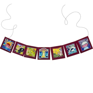 May include: A burgundy fabric banner with seven colorful squares featuring various images of women, flowers, and celestial bodies. The banner is strung on a black cord.