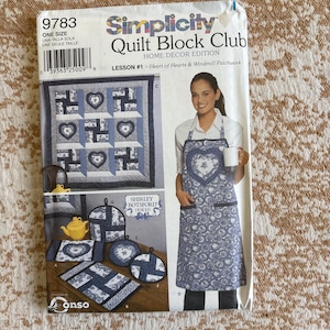 May include: A Simplicity Quilt Block Club pattern, featuring a heart and windmill patchwork design. The cover displays a quilt, apron, and other home decor items. The pattern includes the text "Lesson #1 - Heart of Hearts & Windmill Patchwork."