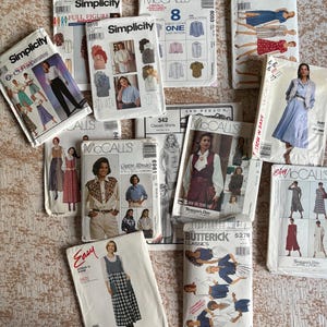 May include: A collection of vintage sewing patterns from Simplicity, McCall's, and Butterick. The patterns feature illustrations of clothing designs, including dresses, shirts, and separates. The patterns are in various sizes and styles.