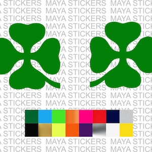 以下が含まれることがあります： 緑色の四つ葉のクローバーのステッカーが2つ。ステッカーは、"MAYA STICKERS"というテキストが繰り返されている白い背景の上にあります。