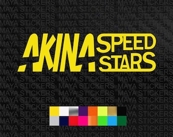 Pode incluir: Adesivo de vinil amarelo com o texto "AKINA SPEED STARS" em uma fonte estilizada. O adesivo está em um fundo preto.