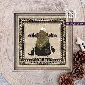 Peut inclure: Motif de point de croix représentant une sorcière avec des chats noirs, un croissant de lune et des maisons. Le texte "Witch's Brew" est en bas. L'œuvre est encadrée dans un cadre en bois.