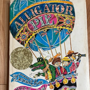 Könnte beinhalten: Ein Vintage-Kinderbuchcover mit einem bunten Heißluftballon mit dem Titel "Alligator Pie". Der Ballon ist gefüllt mit einem grünen Alligator, zwei Kindern und einem Mann mit einem Teleskop. Das Buch ist von Dennis Lee mit Bildern von Frank Newfeld und wurde von Macmillan Canada veröffentlicht.