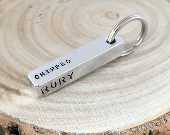 May include: Silver bar keychain with the words "Chipped" and "Rory" engraved on it.