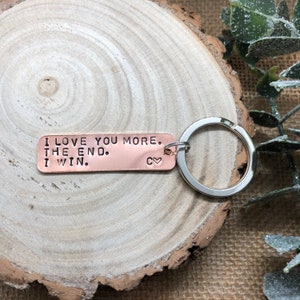 May include: Copper keychain with the text "I love you more. The end. I win." and a small heart symbol.