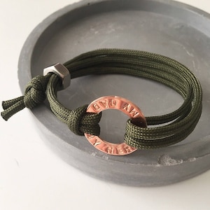 May include: A green paracord bracelet with a copper ring charm that reads "My Own Way".