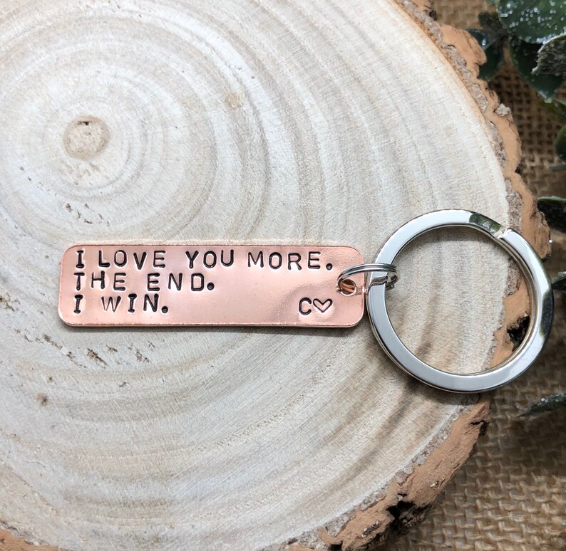 May include: Copper keychain with the text "I love you more. The end. I win." and a small heart symbol.
