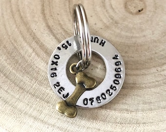 May include: Silver dog tag with a bone charm. The tag has the text "HUN" and a phone number "07802509694".