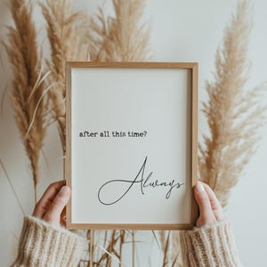 May include: A rectangular wooden frame containing a white print with the black text "after all this time?" in a typewriter font at the top and the word "Always" in a black cursive script font positioned below the center of the frame.