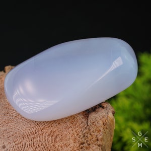 Pode incluir: Uma gema de calced&ocirc;nia lisa, azul claro, polida a alto brilho. A pedra tem formato oval e tem uma apar&ecirc;ncia transl&uacute;cida.