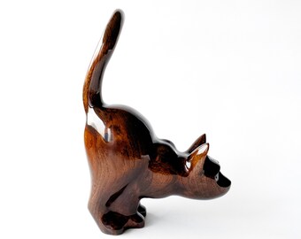 Figura de gato agachado tallada a mano en madera.