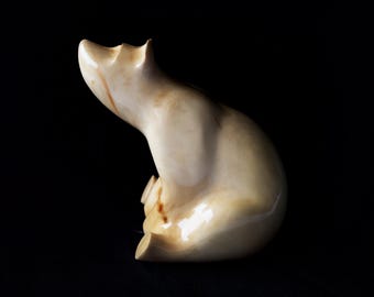 Figura de oso polar de madera tallada a mano, en posición sentada.
