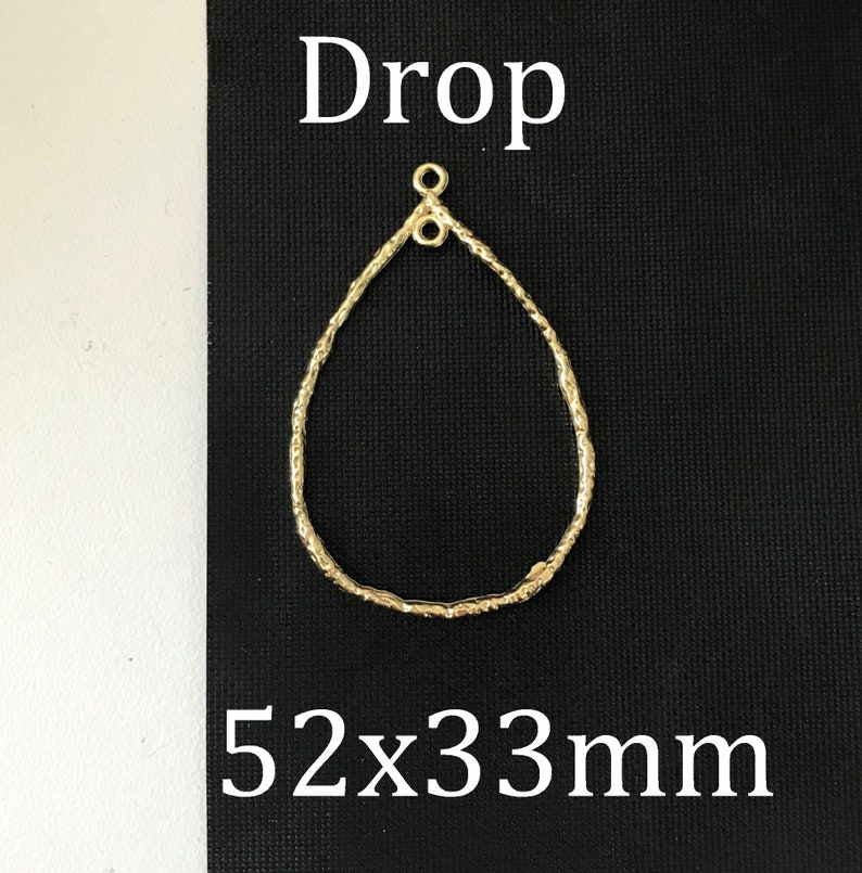 May include: Gold teardrop-shaped earring finding with a textured surface. The finding measures 52 x 33 mm.