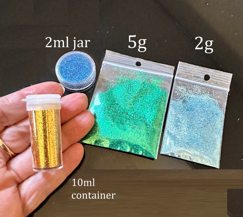 May include: Assortment of glitter in various colors and sizes.  A small 2 ml jar of blue glitter, a 5 g bag of green glitter, a 2 g bag of light blue glitter, and a 10 ml container of gold glitter.
