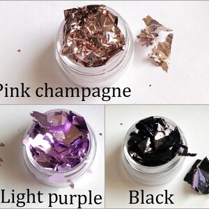 May include: Three small jars of loose metallic flakes. The jars are labeled "Pink champagne", "Light purple", and "Black".