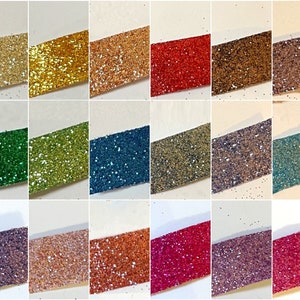 May include: A collection of 18 different colors of glitter, each displayed on a white background. The glitter is arranged in rows of three, with each row containing six different colors.