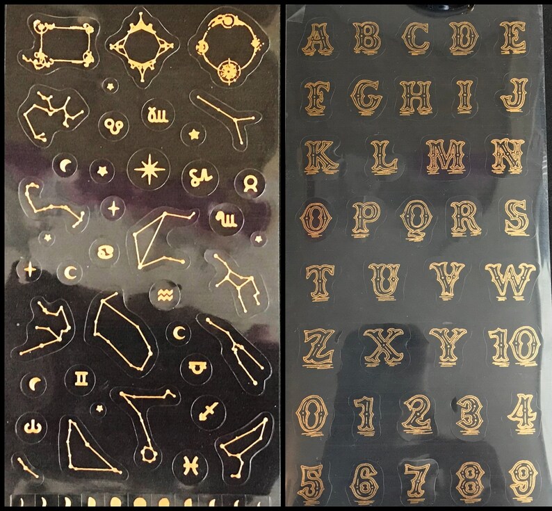 May include: Two sheets of gold sticker paper. One sheet features constellations and celestial symbols. The other sheet features the alphabet and numbers in a decorative font.