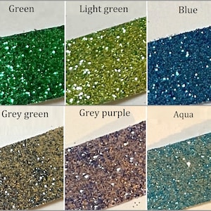 May include: Six samples of glitter in different colors: green, light green, blue, grey green, grey purple, and aqua.