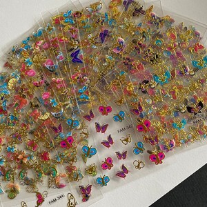 May include: A set of 10 sheets of gold butterfly stickers. Each sheet features a variety of colorful butterflies with gold accents. The sheets are labeled with the product codes FAM-3441, FAM-342, and FAM-3151.