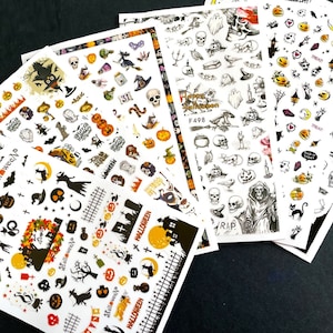 Op de afbeelding: Vijf vellen met Halloween-thema nagelstickers. De stickers bevatten verschillende Halloween-iconen zoals pompoenen, vleermuizen, geesten, schedels, heksen en de woorden "Halloween" en "Treat".