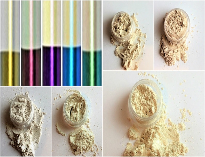 May include: Four small jars of loose, shimmery, light beige eyeshadow pigment. The jars are open and some of the pigment has spilled out.