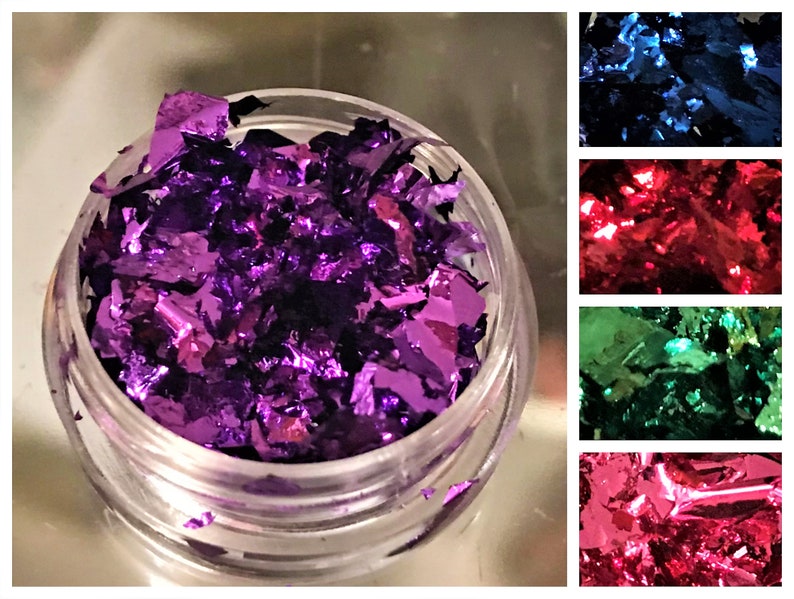 May include: A small clear jar filled with loose purple metallic flakes. The flakes are iridescent and have a shiny finish.