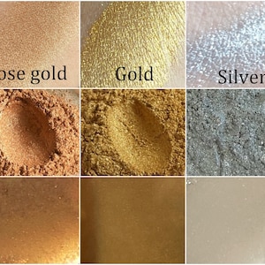 K&ouml;nnte beinhalten: Eine Sammlung metallischer Puder in Ros&eacute;gold-, Gold- und Silberfarben. Das Bild zeigt die Puder in verschiedenen Formen, einschlie&szlig;lich losem Pigment und Farbfeldern. Der Text kennzeichnet jede Farbe: Ros&eacute;gold, Gold und Silber.