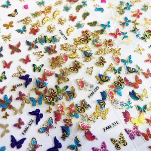 May include: Assortment of colorful butterfly nail art stickers. The stickers feature various butterfly designs with gold accents. The stickers are packaged on sheets labeled with the product code, such as "FAM-328" and "FAM-331".