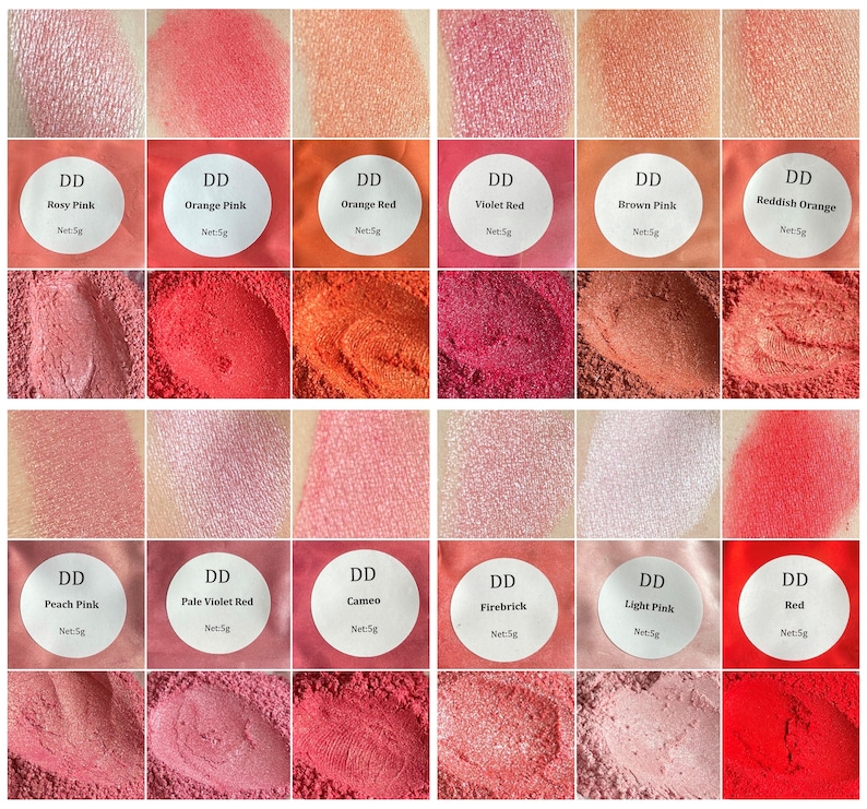 May include: A collection of 12 small jars of red, pink, and orange pigment powder. Each jar has a white label with the text "DD" and the name of the color, such as "Rosy Pink" or "Orange Red".