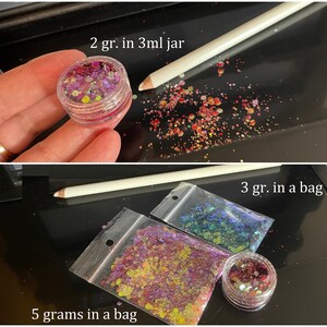 May include: Glitter in a clear jar and bags. The jar contains 2 grams of glitter. The bags contain 3 grams and 5 grams of glitter. The glitter is a mix of colors, including pink, purple, yellow, and blue.