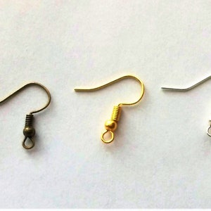 May include: Three earring hooks in different colors: bronze, gold, and silver. Each hook has a small ball at the end and a spring.